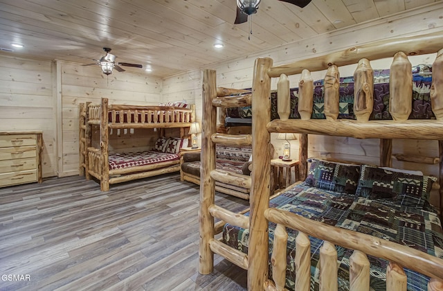 bedroom with wooden walls, wooden ceiling, and hardwood / wood-style flooring