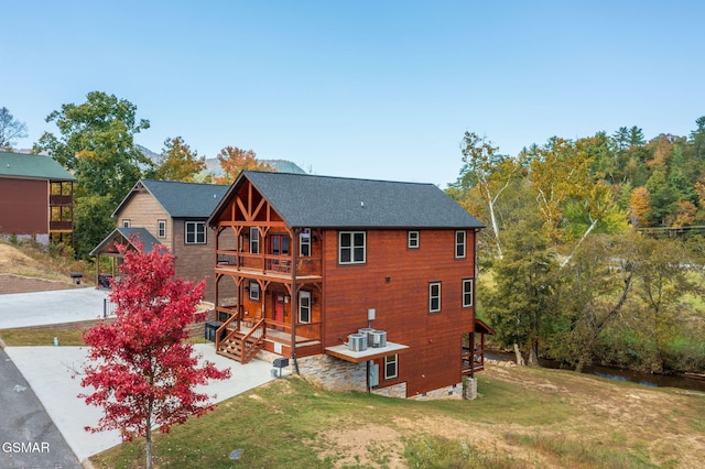 rear view of house with a lawn and central AC unit