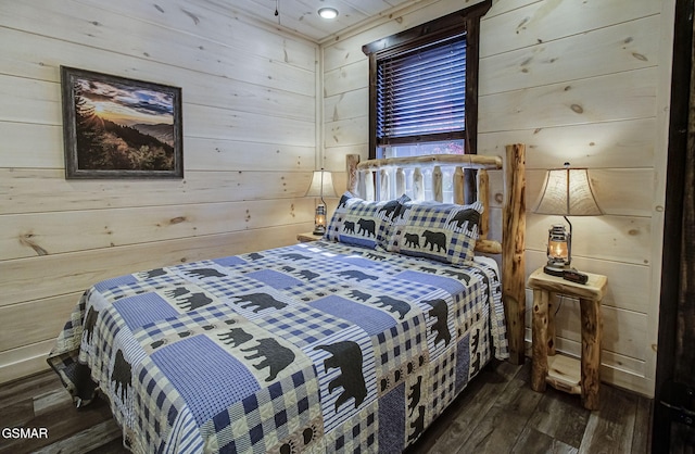 bedroom with dark wood-type flooring and wood walls