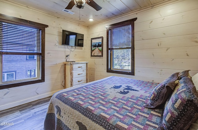 bedroom with hardwood / wood-style floors, ceiling fan, wooden ceiling, and wood walls