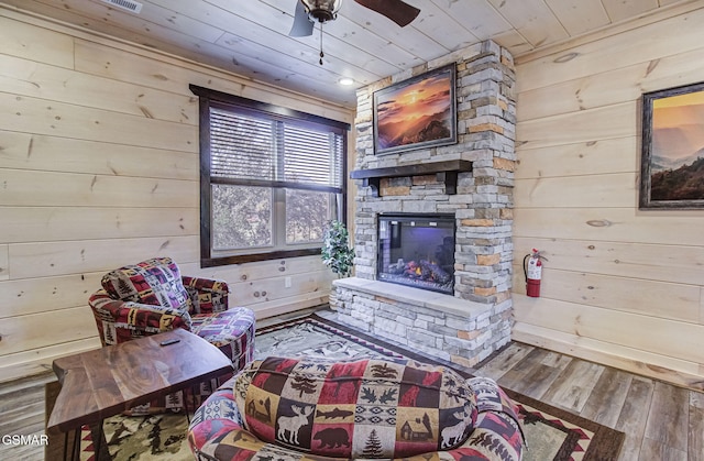 living area with wood walls, wood-type flooring, a fireplace, and wood ceiling