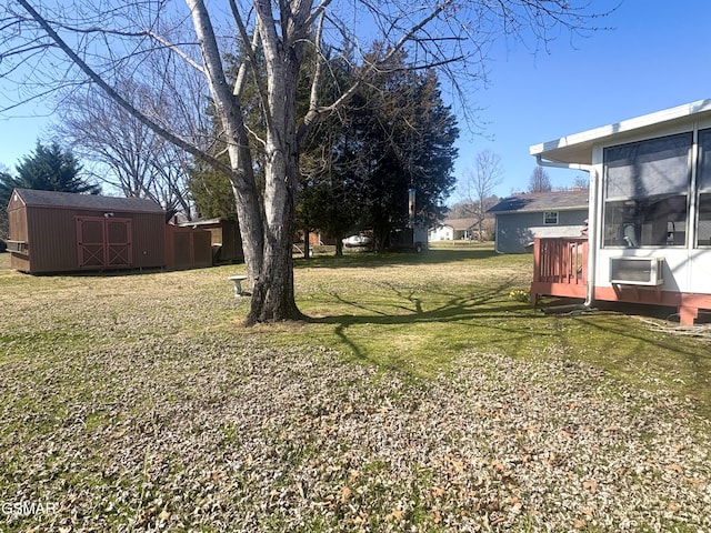 view of yard featuring a sunroom, an outdoor structure, and a storage shed