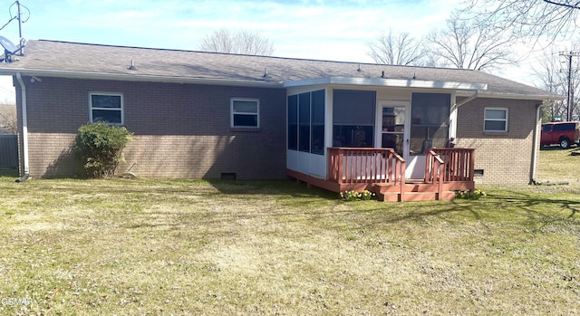 rear view of property with crawl space, a sunroom, a lawn, and brick siding