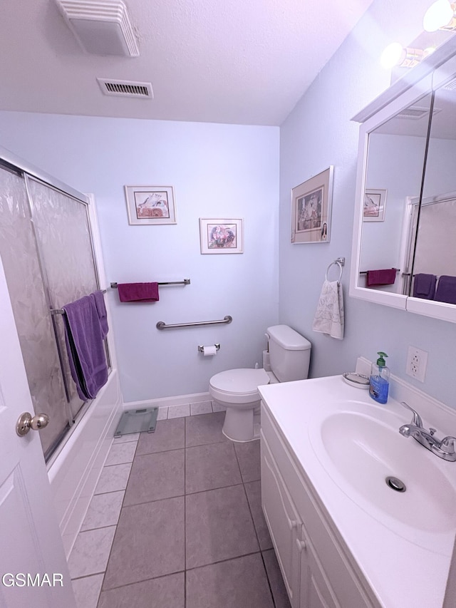 bathroom with visible vents, bath / shower combo with glass door, toilet, tile patterned flooring, and vanity