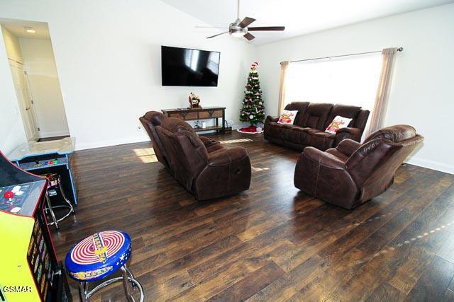 living room with ceiling fan and dark wood-type flooring