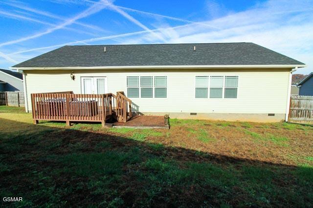 back of house with a wooden deck and a yard