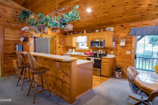 kitchen featuring wooden ceiling, a breakfast bar area, vaulted ceiling, kitchen peninsula, and stainless steel appliances