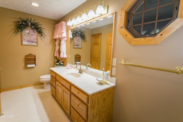 bathroom with vanity, a textured ceiling, and toilet