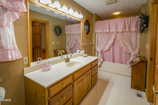 bathroom with vanity, shower / bath combination with curtain, and a textured ceiling