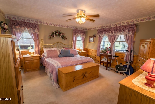 carpeted bedroom featuring multiple windows, ceiling fan, and a textured ceiling