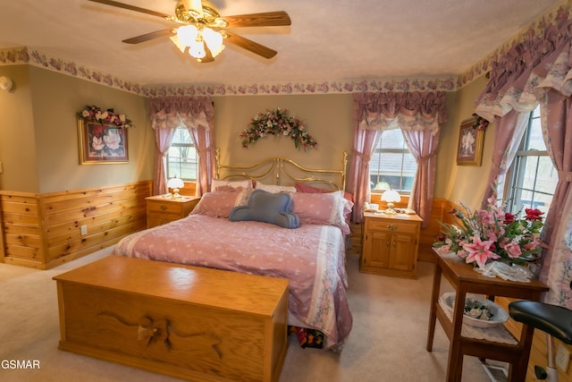 bedroom with multiple windows, ceiling fan, light carpet, and a textured ceiling