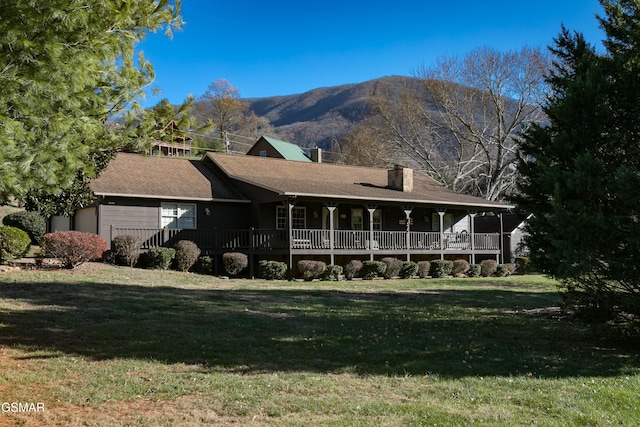 view of front of property featuring a mountain view and a front lawn