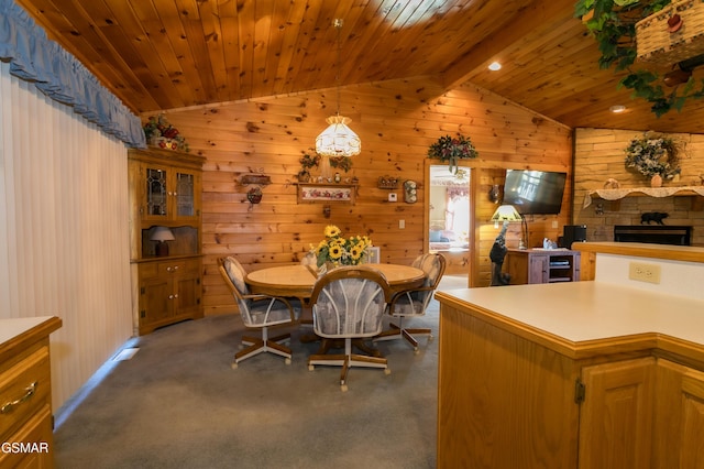 carpeted dining area featuring beverage cooler, vaulted ceiling with beams, wood walls, a fireplace, and wood ceiling