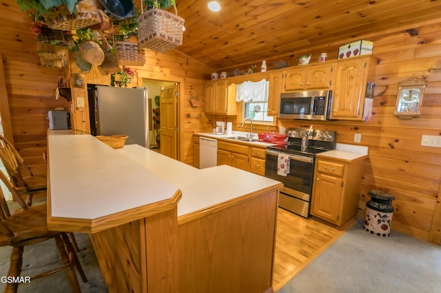 kitchen featuring kitchen peninsula, wood ceiling, stainless steel appliances, vaulted ceiling, and sink