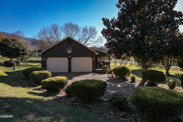 view of front of house with a mountain view, a garage, and a front lawn