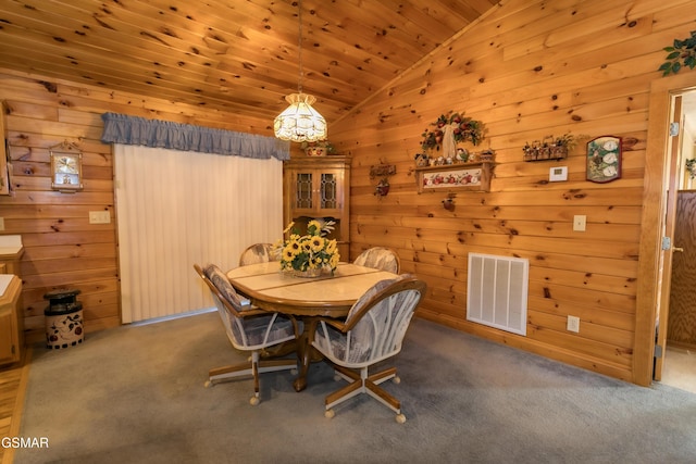 dining room featuring carpet flooring, lofted ceiling, wooden walls, and wood ceiling