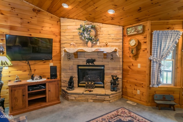 carpeted living room featuring a stone fireplace, wooden walls, wood ceiling, and lofted ceiling