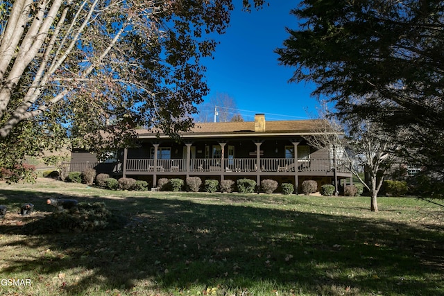 rear view of property featuring a lawn