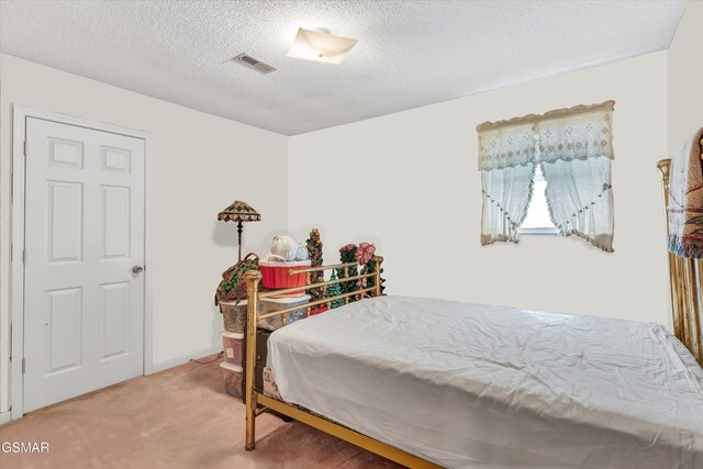 bedroom featuring carpet and a textured ceiling