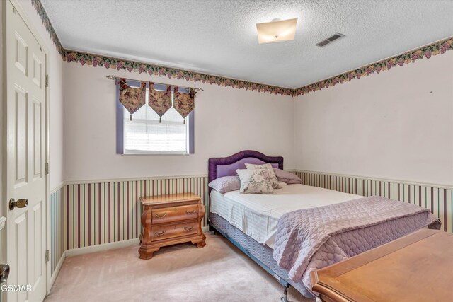 bedroom with carpet and a textured ceiling