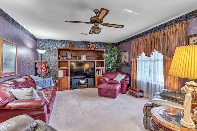 living room featuring carpet, ceiling fan, and a textured ceiling