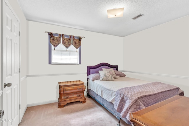 bedroom featuring carpet flooring and a textured ceiling