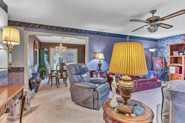 living room with carpet flooring and ceiling fan with notable chandelier