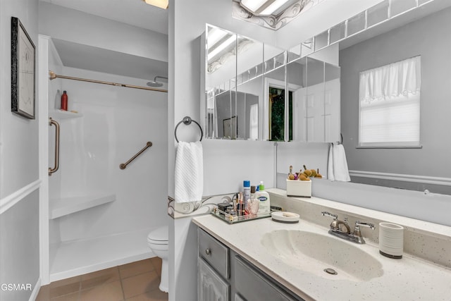 bathroom featuring a shower, vanity, tile patterned flooring, and toilet