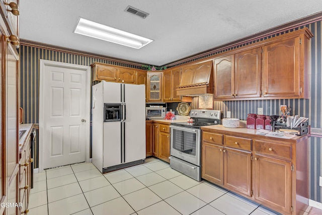 kitchen with stainless steel electric stove, custom exhaust hood, light tile patterned flooring, and white fridge with ice dispenser