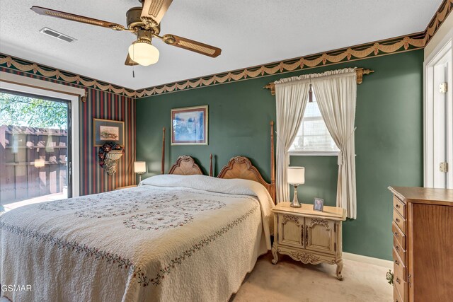 bedroom featuring ceiling fan, light colored carpet, and a textured ceiling