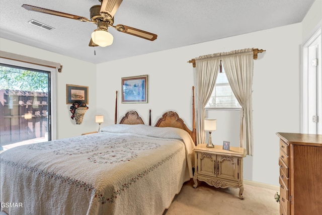 bedroom with light carpet, a textured ceiling, and ceiling fan