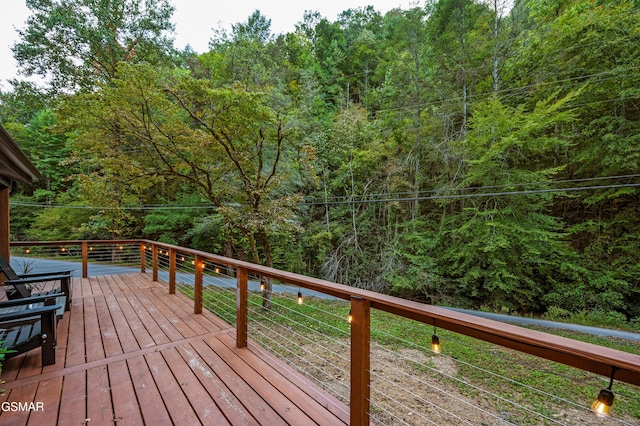 wooden terrace featuring a view of trees