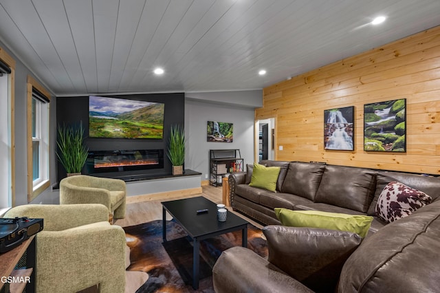 home theater room featuring recessed lighting, a glass covered fireplace, wood ceiling, wooden walls, and wood finished floors