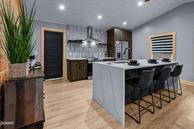 3033 N Clear Fork Rd, Sevierville, TN 37862 - kitchen featuring light countertops, appliances with stainless steel finishes, a breakfast bar area, and wall chimney exhaust hood
