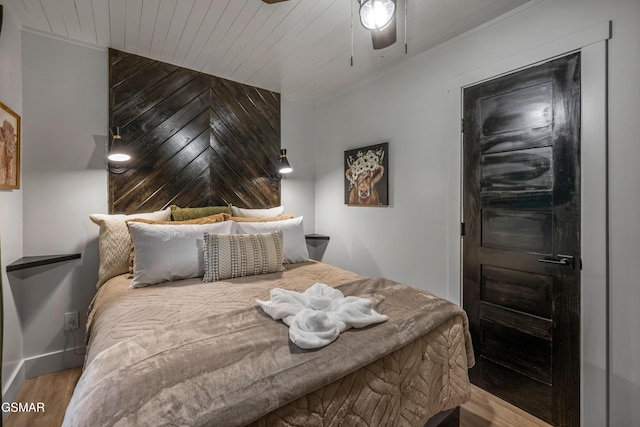 bedroom with wood ceiling, wooden walls, ceiling fan, and wood finished floors