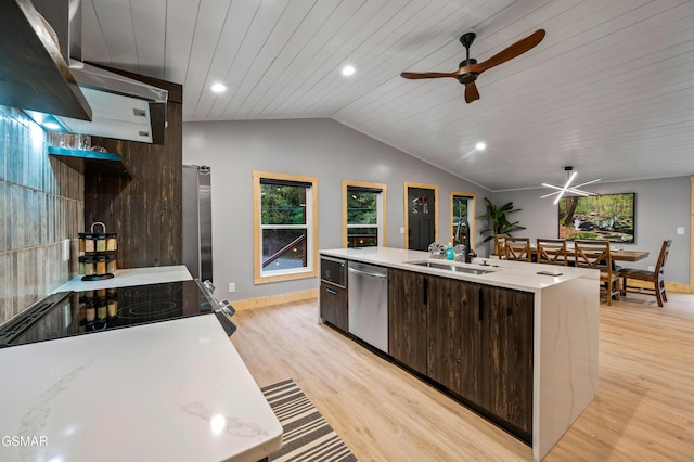 kitchen featuring modern cabinets, vaulted ceiling, dark brown cabinets, stainless steel appliances, and a sink