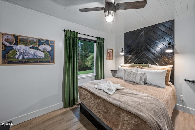 bedroom with wooden ceiling, wood finished floors, a ceiling fan, and baseboards