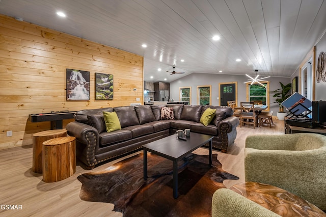 living area featuring lofted ceiling, light wood-style flooring, wood walls, and wood ceiling