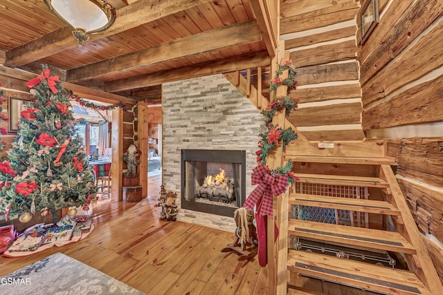 interior space with a fireplace, wood-type flooring, and beamed ceiling