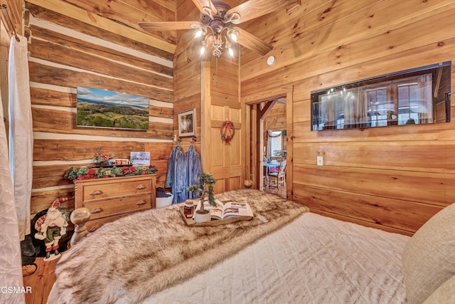 bedroom with ceiling fan and wooden walls