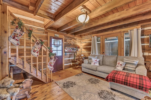 living room featuring beamed ceiling, light wood-type flooring, wooden walls, and wood ceiling