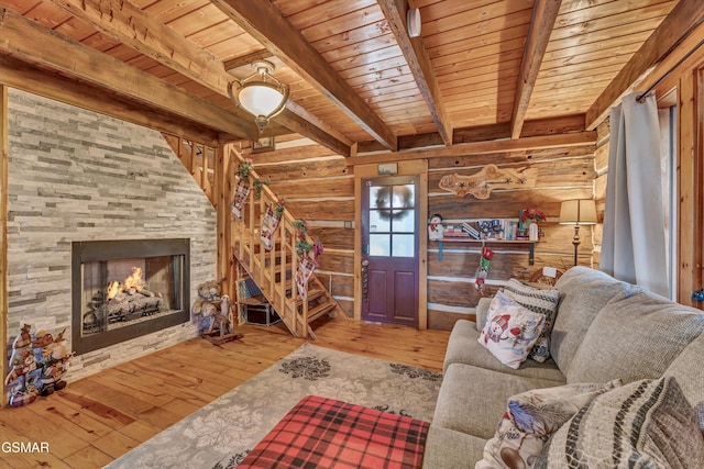 unfurnished living room with beam ceiling, rustic walls, hardwood / wood-style floors, a fireplace, and wood ceiling