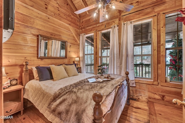 bedroom featuring wood ceiling, ceiling fan, wood-type flooring, multiple windows, and vaulted ceiling with beams