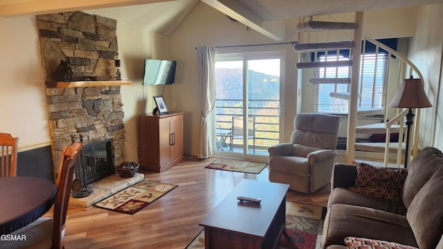 living room featuring light hardwood / wood-style floors and a stone fireplace