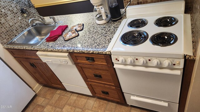 kitchen with decorative backsplash, white appliances, and sink