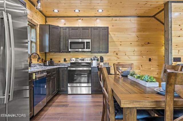 kitchen with stainless steel appliances, dark brown cabinets, wooden ceiling, and light stone countertops