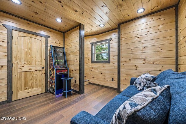 sitting room featuring dark wood-type flooring, recessed lighting, wooden ceiling, and wood walls