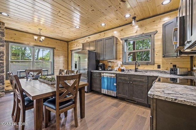 kitchen with stainless steel appliances, wooden ceiling, dark brown cabinetry, and light stone countertops