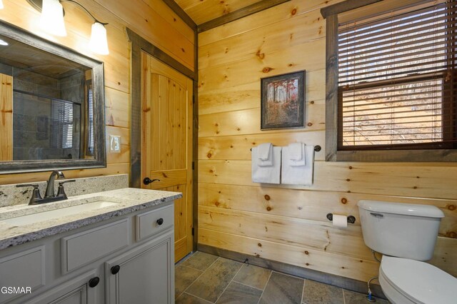 full bathroom with toilet, wooden walls, walk in shower, and vanity