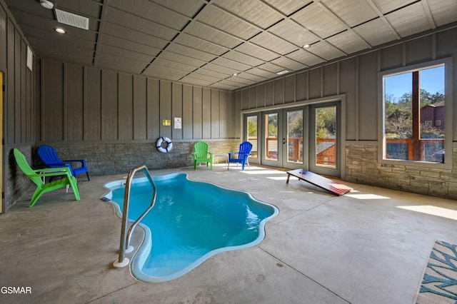 view of swimming pool with french doors